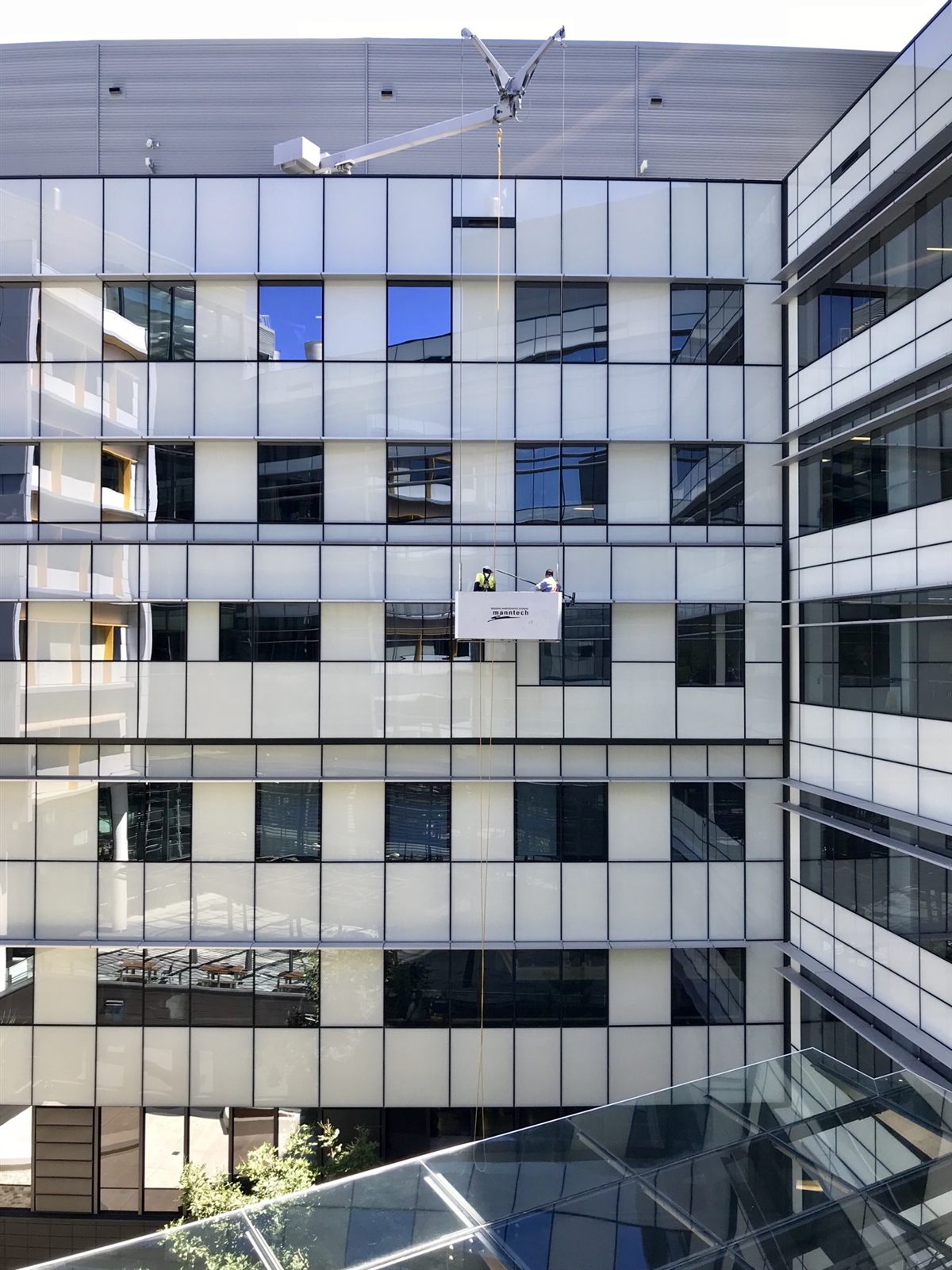 BMU (Building Maintenance Unit) sepetiyle cam cephe temizliği — temsili görsel