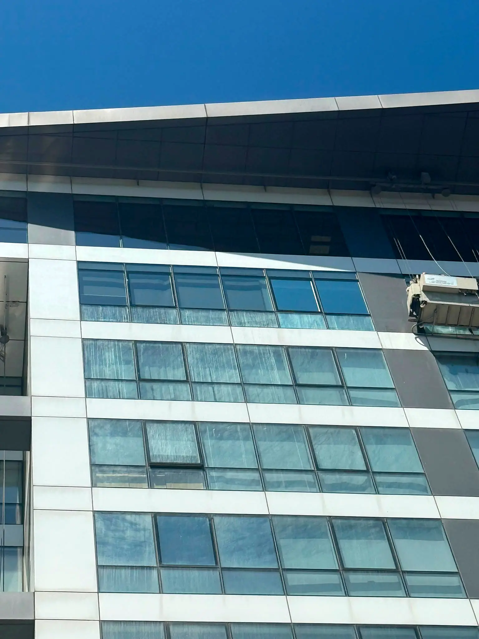 Kirli cam cephede asılı BMU bakım sepeti, dış cephe temizliği öncesi durum