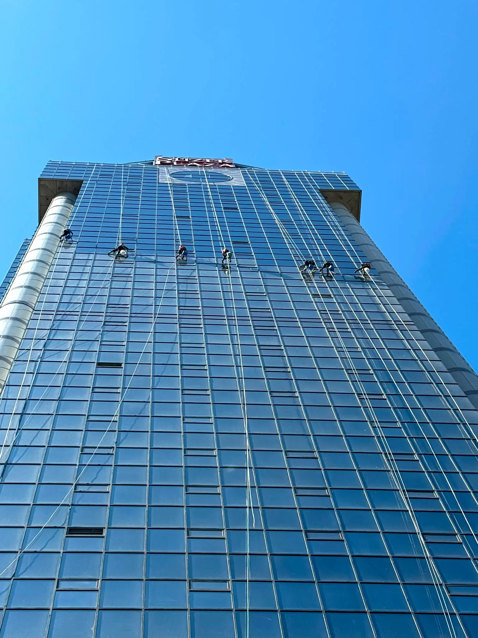 Süzer Plaza (Levent, İstanbul) cam cephesinde iple erişimle temizlik yapan 7 kişilik ekip